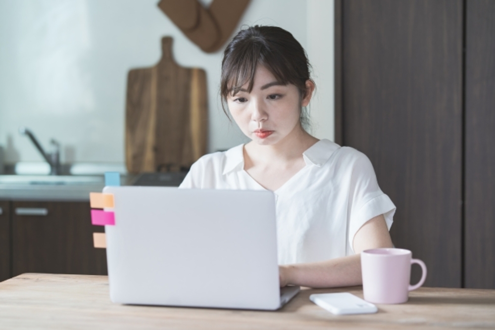 パソコンに真剣に向かう女性。中国語オンラインレッスンの効果を高めるために努力している。