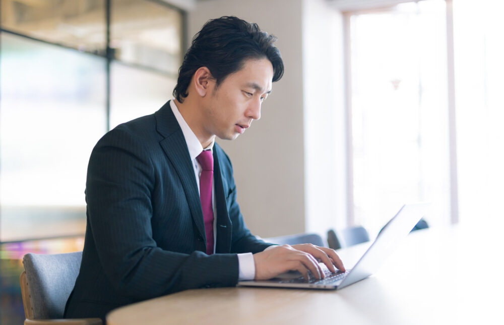 男性がノートパソコンに向かっている横顔を写す。ネイティブが感じる簡体字と繁体字の印象について解説する。