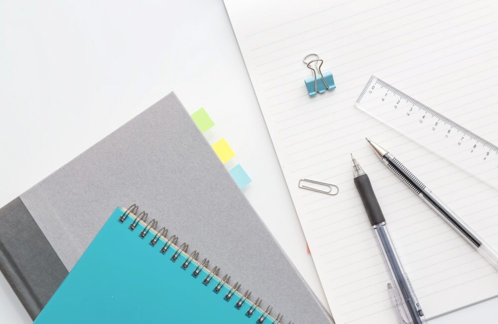 ノートと定規とペンが置かれている。中国語検定とHSKの準備のための学習中。