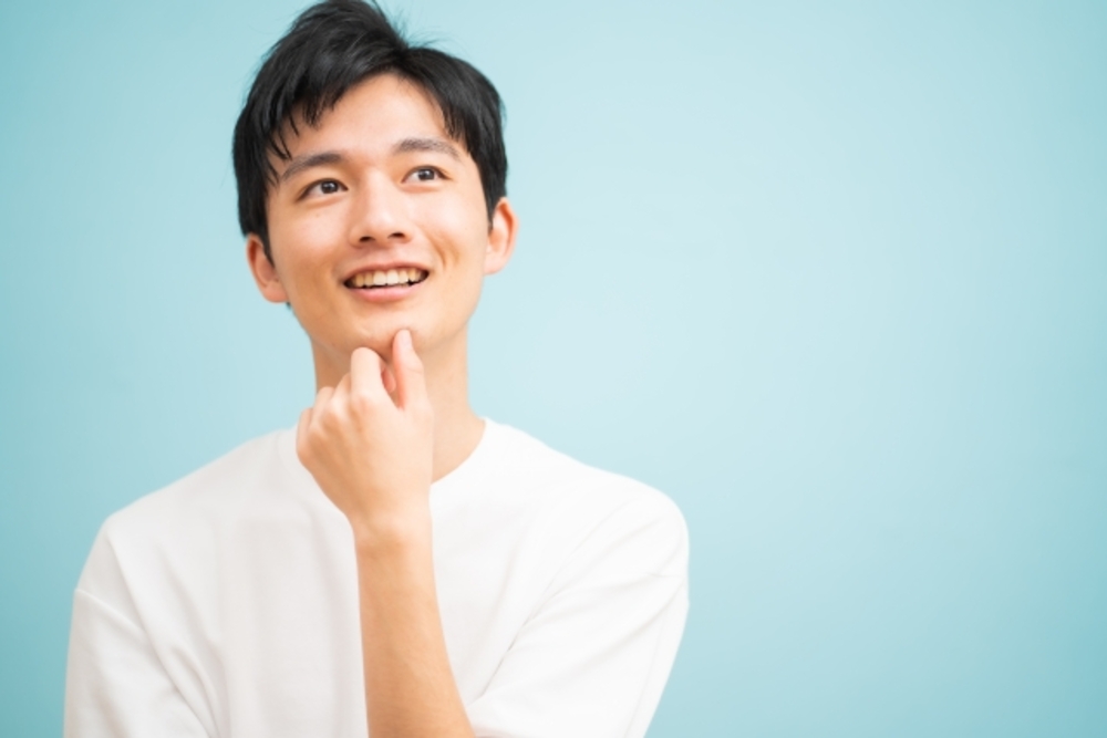 顎に手を当てて斜め上を見る男性。中国語でかっこいいと褒める表現を考えて見る。